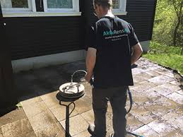 Aktiv Rens medarbejder i gang med professionel fliserens af terrasse